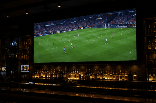 Large LED screen and ticker above the main bar of a pub
